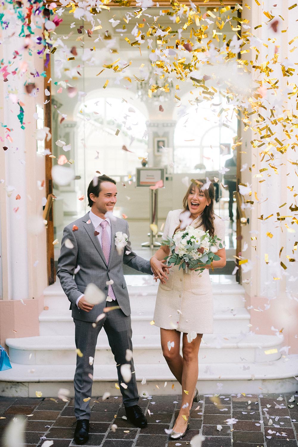 les maries sortent de la mairie ils s'embrassent elle est en robe de mariage a paris